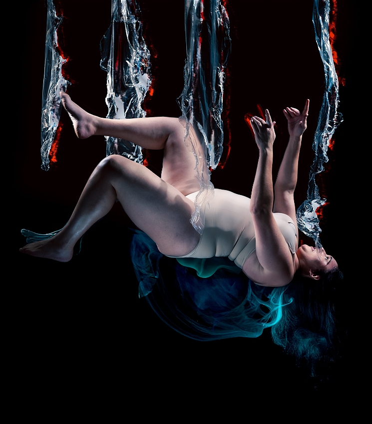 A dark-haired person in a nude bodysuit is falling side-on, facing towards the top of the image. They are against a black background with a blue smoky aura around them. Their face is side-on, and in shock. There are tendrils of blue and red light falling like water vertically down the image towards them.