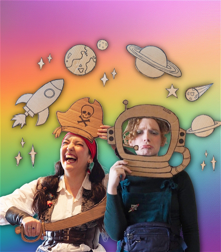 Two people against a rainbow background. On the left is a pirate (Kat Glass) laughing joyfully, they hold a cardboard pirate hat and sword. On the right is an astronaut (Fia Haugh) pouting grumpily, she is holding a cardboard space helmet. They are surrounded by small cardboard cutouts of planets, stars, and rocket ships.