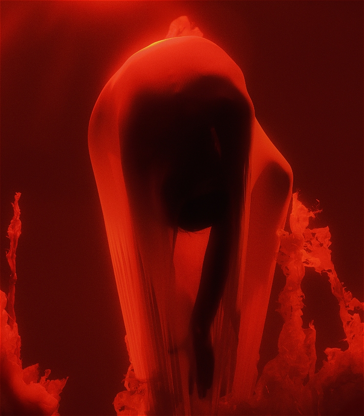 A red background with a person enclosed in a womb hanging upside down.