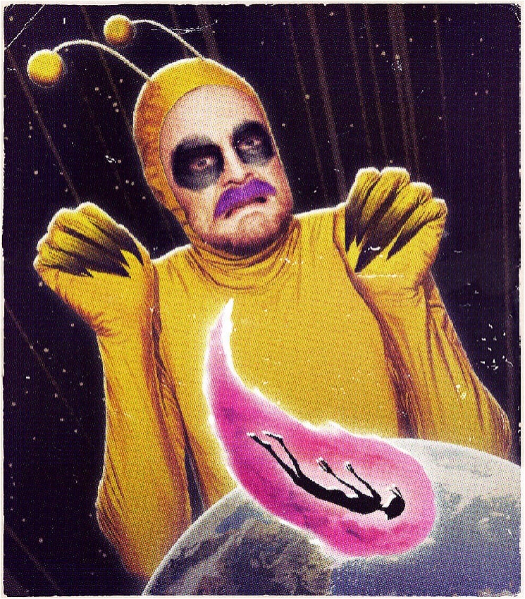 Lukas dressed as a yellow alien with dark black makeup around their eyes, and a purple moustache. looking over the earth with a pink comet with an alien inside makes its way across the surface of the earth. They look scared.