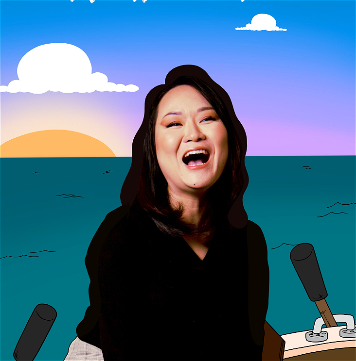 A Chinese Woman sitting on a chair laughing with her mouth wide open.