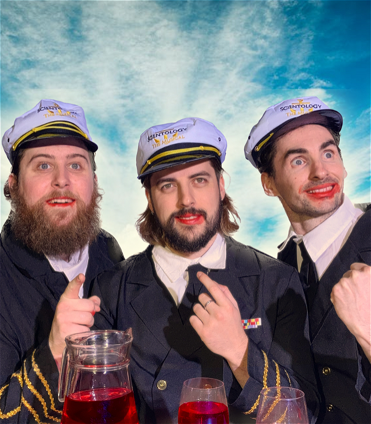 Three men in sailors suits and with red food dye around their mouths look to the skies!