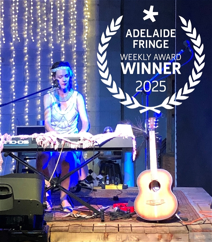 Lead performer Marie-Thérèse wears a white flapper dress with 1920's style white head band, looking at her hands whilst playing piano. On the stage is a guitar and fold-back speaker. The stage is lit with a blue wash and fairy lights dripping down the back wall. An award with laurels consumes the top right corner of the image, with the words - 'ADELAIDE FRINGE WEEKLY AWARD WINNER 2025'