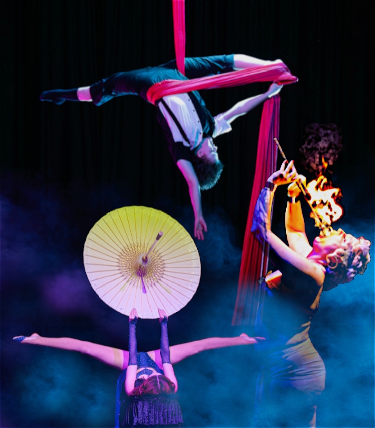 there is a black background with blue smoke floating around 3 performers - one who is eating fire. another who has there legs opened in a split and holding a big open-umbrella like object. and at the top of the picture is a performer who is hanging upside down with a red fabric wrapped around their hips and looped on one foot, while also in a split.